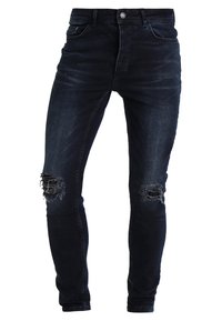 Tummansiniset kapeat farkut, tehty denimistä, joissa kulutetut repeämät polvissa, viisi taskua ja nappikiinnitys vyötäröllä.