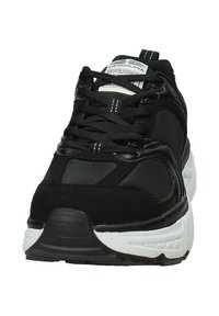 Scarpe da ginnastica nere con una tomaia sintetica liscia, pannelli testurizzati e suola bianca. Presentano lacci spessi e un colletto imbottito.