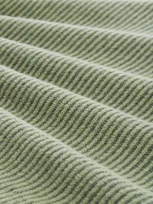 Tela de rayas verdes y grises con superficie texturizada, que presenta un patrón ondulado y tacto suave, doblada en capas.