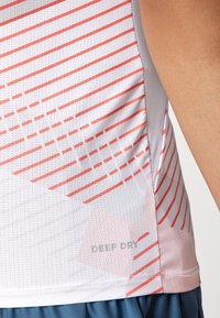 Weißes Sport-Tanktop mit pinken diagonalen Streifen, Netztextur und "DEEP DRY"-Druck in der Nähe des Saums. Weicher Stoff mit feuchtigkeitsableitenden Eigenschaften.