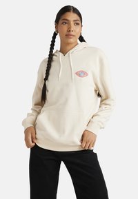 Kremowy hoodie z przednią kieszenią, z czerwono-niebieską grafiką oka na lewej piersi. Wykonany z miękkiego materiału, luźny krój.