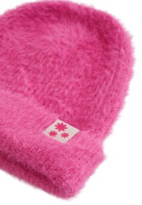 Rožinis pūkuotas kepurės bžūp iš minkštos medžiagos, apvalios formos, su balta etikete ir gėlių grafikos akcentais. Jaukus ir tekstūruotas išvaizdos.