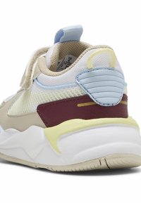 Scarpa sportiva beige con una parte superiore testurizzata, accenti blu, pannello bordeaux e un dettaglio giallo, dotata di collo imbottito e suola robusta.