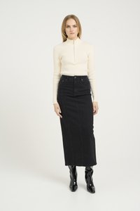 Maglione a coste crema a maniche lunghe con colletto alto, abbinato a una gonna a tubino in denim nera e stivaletti neri lucidi. Design minimalista.