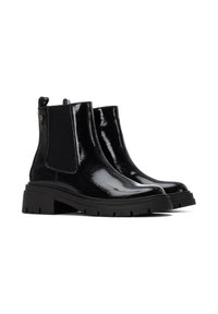 Botines de charol negro con paneles laterales elásticos, punta redondeada y suela de goma gruesa con un patrón de relieve.