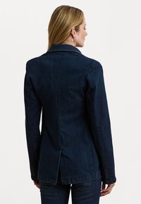 Donkerdenim blazer met een gekarteld kraag, gestructureerde schouders, enkele split achter en knoopaccenten op de mouwen.