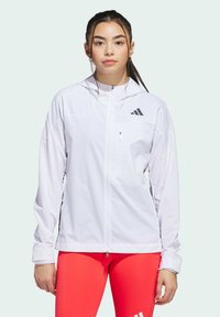 Veste de sport blanche avec fermeture éclair sur le devant, capuche et logo noir brodé. Fabriquée en tissu respirant avec une coupe épurée.