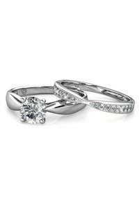 Twee zilveren trouwringen, één met een grote ronde diamanten centerpiece en de ander met een rij kleinere diamanten langs de band.