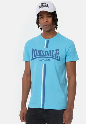 Light blue crew-neck t-shirt with large "Lonsdale London" print, featuring white and dark blue vertical stripes on the front.