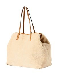 Borsa tote in pelliccia sintetica beige con manici in pelle marrone. Ampia, morbida al tatto, di forma arrotondata. Design minimalista senza hardware visibile.
