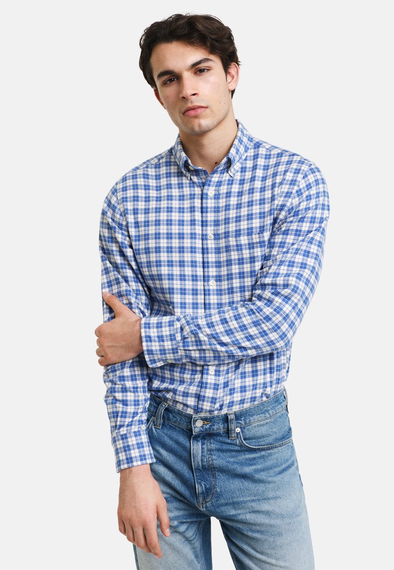 Blå og hvit rutete skjorte med lange ermer, med krage og en avslappet passform, sammen med lyseblå denimjeans.