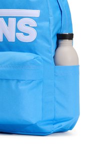 Modrý batoh s bílým nápisem, se boční kapsou obsahující šedou láhev na vodu s černým víčkem, vyrobený z odolné látky.