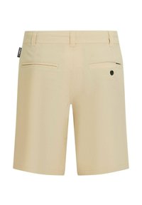 Pantalones cortos beige con textura suave, corte a medida, dos bolsillos traseros y un pequeño detalle de etiqueta negra en el lateral.
