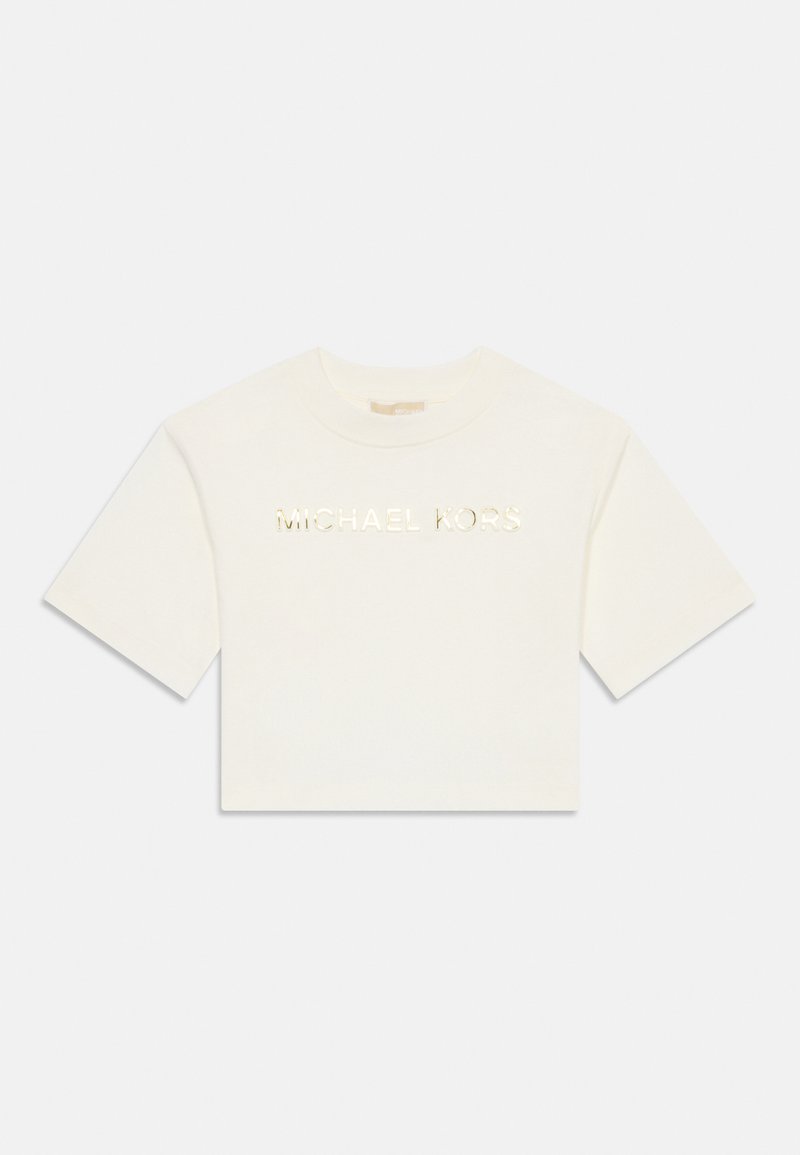 Balta trumpa rankovėmis marškinėliai su auksiniu metaliniu užrašu "MICHAEL KORS", centruotu ant priekinės dalies priešais vientisą foną.