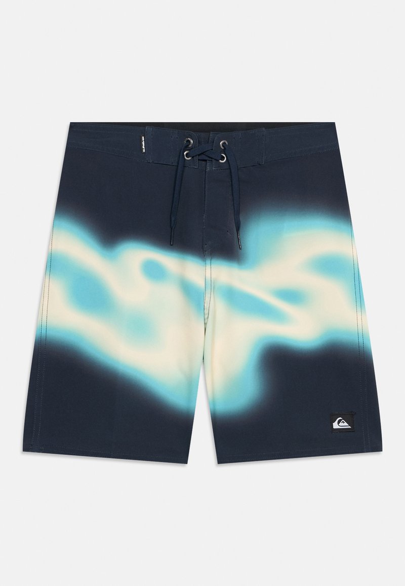 Μακριά μαγιό σε ναυτικό μπλε χρώμα με ανοιχτό μπλε και λευκό αφηρημένο σχέδιο κυμάτων, μπροστινό κλείσιμο με κορδόνι και μικρό μαύρο λογότυπο στο αριστερό πόδι.