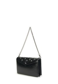 Bolso de mano de cuero negro con una correa de cadena, con una superficie texturizada, tachuelas plateadas y una solapa de estilo sobre con una parte superior en ángulo.