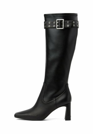 Botte en cuir noire montant jusqu'au genou avec bout pointu, talon bloc et bride décorative avec boucle en haut.