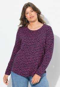 Pitkähihainen t-paita tummansinistä puuvillaa, jossa on vaaleanpunaisia kala-kuvioita, pyöreä pääntie ja rento malli, yhdistettynä vaaleansinisiin farkkuihin.