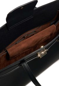 Black leather handbag with a smooth exterior and gold hardware. Interior features brown suede lining and compartments for organization.