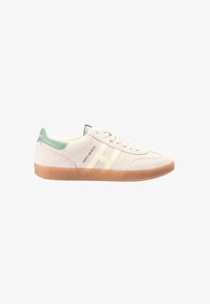 Beige suède sneakers met mintgroene hiel, gele details en een gum rubberen zool. Voorzien van merklogo's aan de zijkant en op de tong.