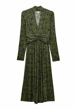 Long-sleeved dress in dark green fabric with intricate black floral pattern, featuring a deep V-neck and gathered waist with pleated skirt.