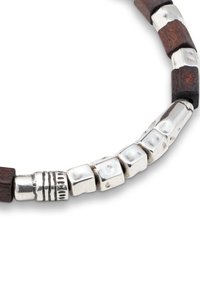 Pulsera de cuentas que combina cuentas de madera y plata; las cuentas de plata tienen un acabado brillante con formas y texturas variadas, y detalles oscuros de madera.