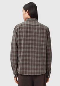 Kariertes Hemd mit Knöpfen in Dunkelgrau, Rot und Creme. Weicher Stoff mit lässiger Passform und Ein-Knopf-Manschetten. Abgerundeter Saum hinten.