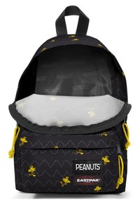 Czarny plecak z tkaniny z żółtym wzorem Snoopy, wyposażony w zapięcie na sznurki, miękko wyściełane wnętrze oraz naszywkę z logo z przodu. Widoczne wyściełane wnętrze.