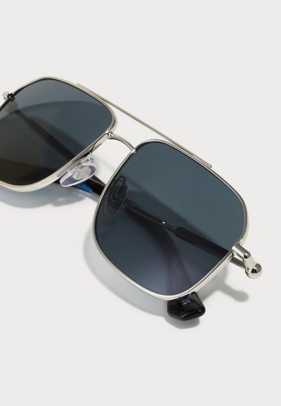 Metal-framed sunglasses with dark lenses. Square lenses, slender bridge, and black temple accents. Anti-slip nose pads included.