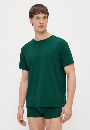 Groen katoenen t-shirt met korte mouwen en een ronde hals, gecombineerd met bijpassende groene shorts. De stof ziet er glad en licht uit.