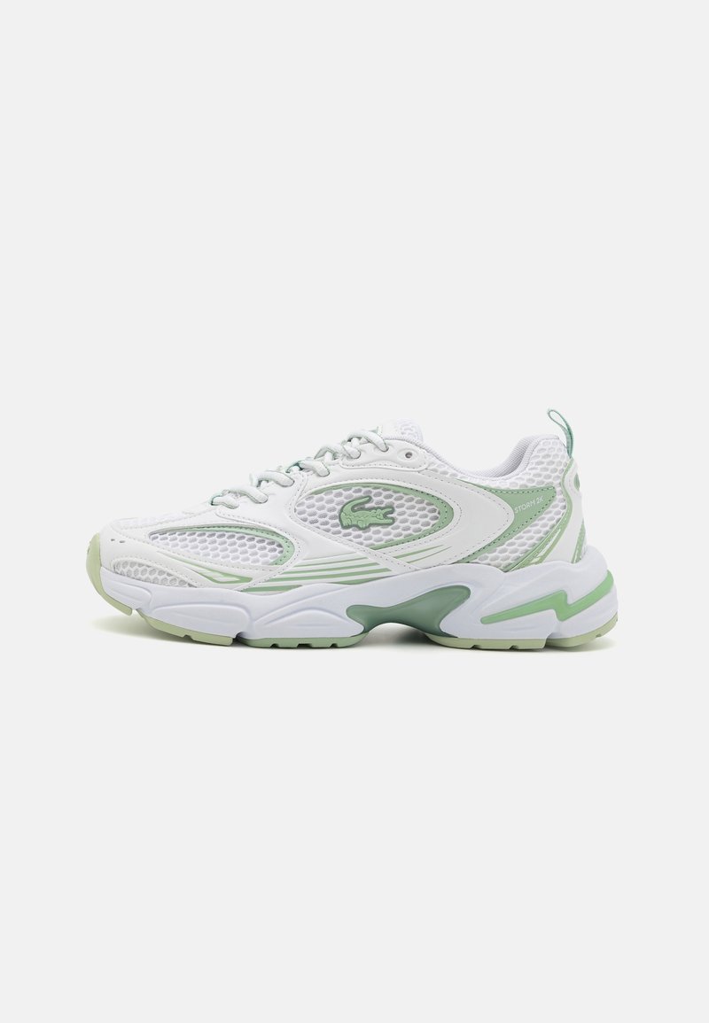 Baskets de sport blanches et vert clair avec panneaux en mesh, fermeture à lacets, semelle rembourrée et logo décoratif sur le côté.