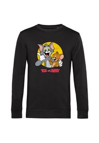 Felpa nera a maniche lunghe con una grafica dei personaggi dei cartoni animati Tom e Jerry, con uno sfondo circolare giallo e testo rosso.