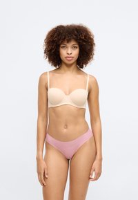 Beige gepolsterter BH mit verstellbaren Trägern und rosa hochgeschnittenem Bikiniunterteil. Glatte Textur, einfaches Design und keine sichtbaren Muster oder Akzente.