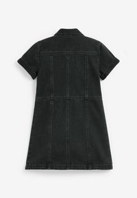 Musta farkkuinen mekko lyhyillä hihoilla, kauluksella ja rakenteellisilla saumoilla. Mekossa on istuva vartalokappale, joka levenee kohti helmaa.