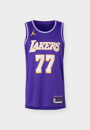 Μωβ φανέλα μπάσκετ των Los Angeles Lakers με τον αριθμό 77, το λογότυπο Jordan και επιγραφή «Leave a Legacy» στο κάτω μέρος.