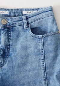 Jeans in denim azzurro chiaro con un design classico, tasche frontali, un bottone in metallo e dettagli cuciti lungo le cuciture.