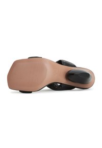 Sandal con tacco nero, con suola in gomma texturizzata e parte superiore liscia e imbottita. Presenta un tacco modellato per un supporto e un comfort aggiuntivi.