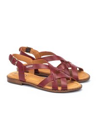 Bruine leren sandalen met gekruiste banden, open achterkant en verstelbare enkelgesp. Voorzien van een gevoerd voetbed en een gestructureerde zool.