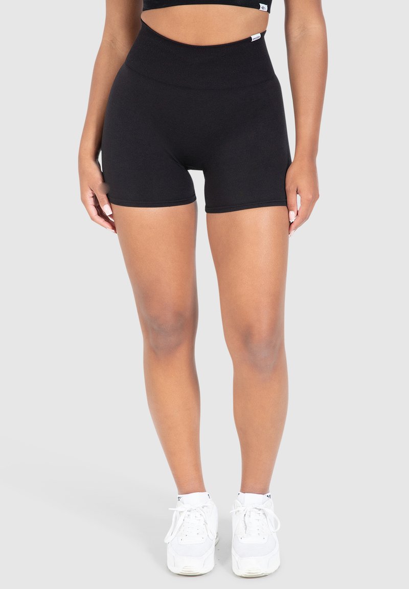 Pantaloni sportivi neri a vita alta con una texture elastica e liscia. Presentano un'increspatura in vita e nessun motivo o hardware visibile.