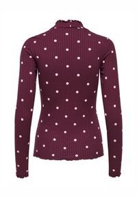 Mørkerød langærmet top med ribbet tekstur, dekoreret med hvide polkaprikker og en flæset krave, designet til en tætsiddende silhuet.