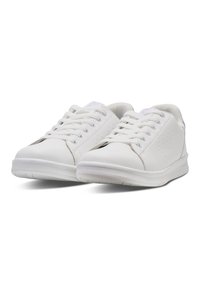 Baskets blanches avec une tige en cuir lisse, bout rond et un laçage à six œillets. Détails perforés subtils sur le côté pour la respirabilité.