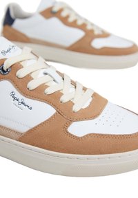Baskets basses en cuir blanc avec des panneaux en daim beige, lacets crème, et logo "Pepe Jeans London" sur le côté.