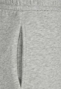 Pantalones de chándal grises con un tejido suave y texturizado, cinturilla elástica y bolsillos laterales, con un diseño limpio y sencillo.