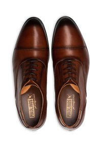 Scarpe eleganti in pelle marrone con finitura liscia, punta arrotondata, dettagli di cucitura discreti e design con lacci.