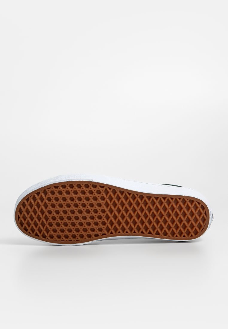 Sneaker mit einem weißen Obermaterial, grünen Akzenten und einer strukturierten braunen Gummisohle mit einem Wabenmuster für besseren Halt.