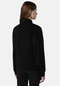 Sudadera negra con cuello alto, tejido texturizado y paneles laterales. Presenta un diseño simple y moderno con puños y bajo acanalados.