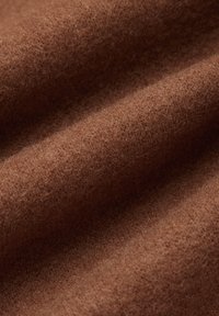 Brązowy filcowy materiał o miękkiej, teksturowanej powierzchni, z gładkim, równym splotem i bez widocznych wzorów czy akcentów.