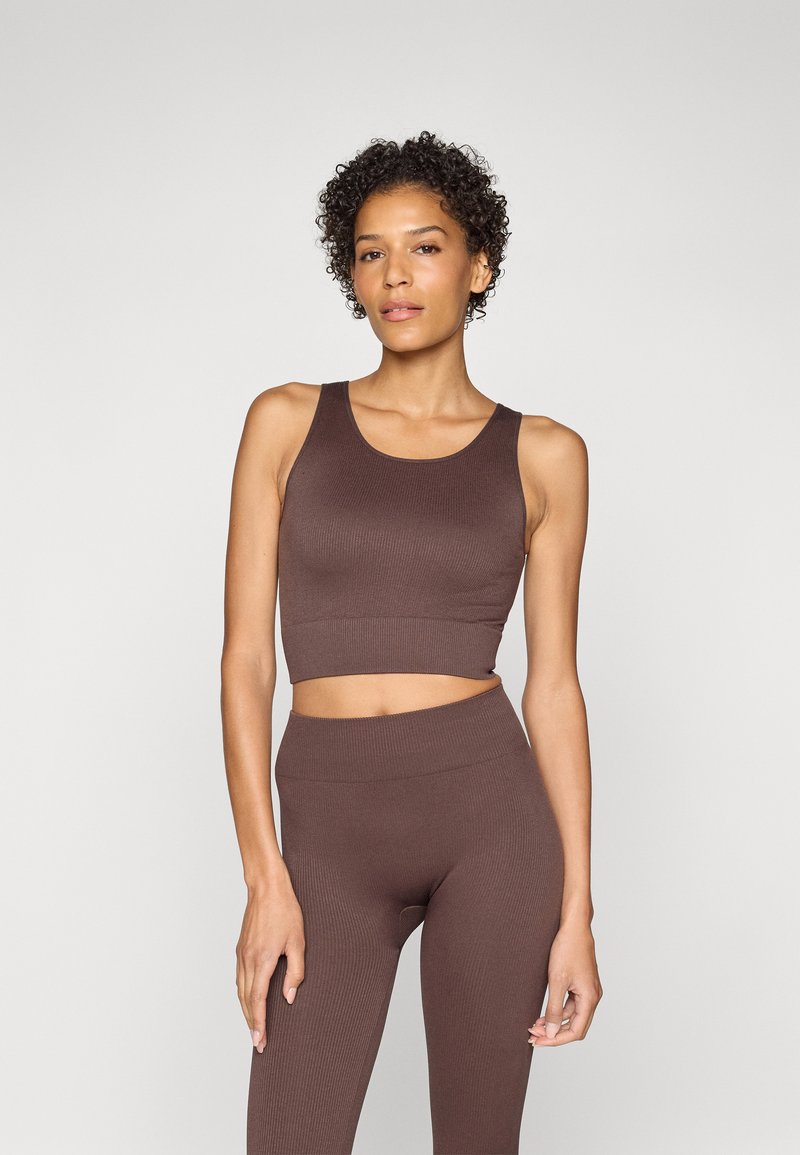 Brown ribbed crop top paired with high-waisted leggings, both featuring a smooth texture and a fitted design.
