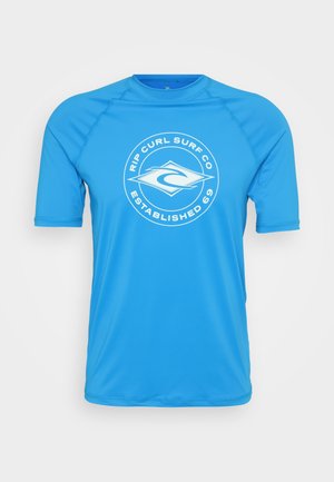 Korte mouw turquoise rash guard gemaakt van gladde, lichte stof. Voorzien van een wit cirkelvormig logo met "RIP CURL SURF CO ESTABLISHED 69."