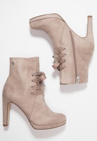 Beige suede high-heeled ankle boots with lace-up fronts and side zippers, displayed on a white background.